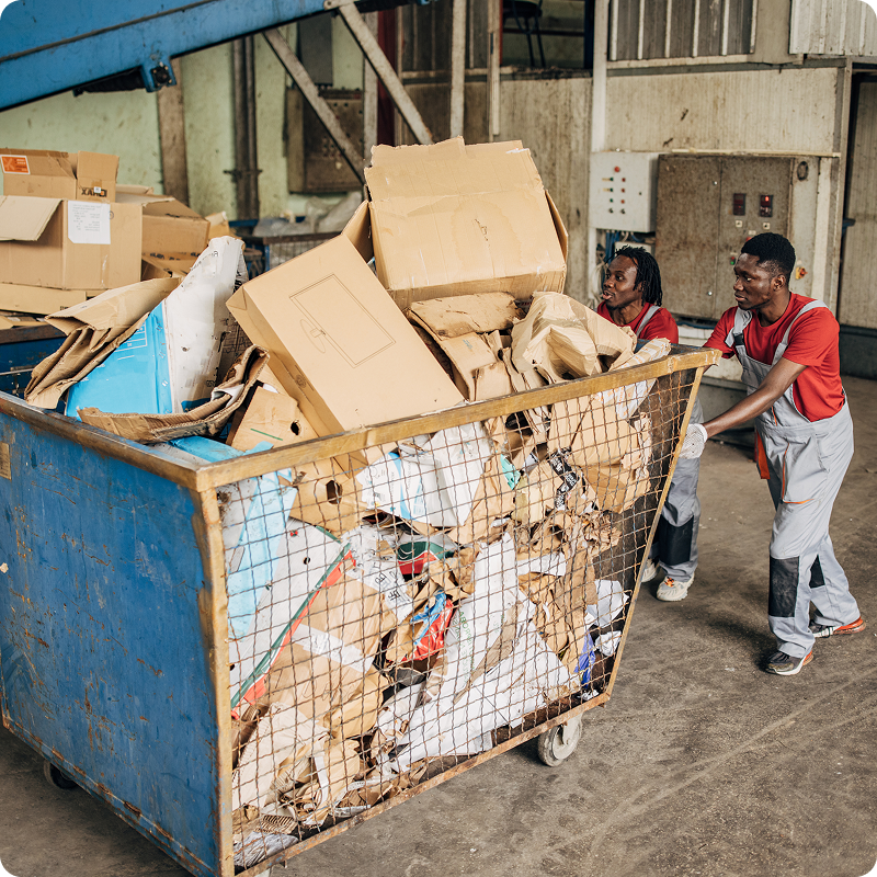Workers moving large recycling bin